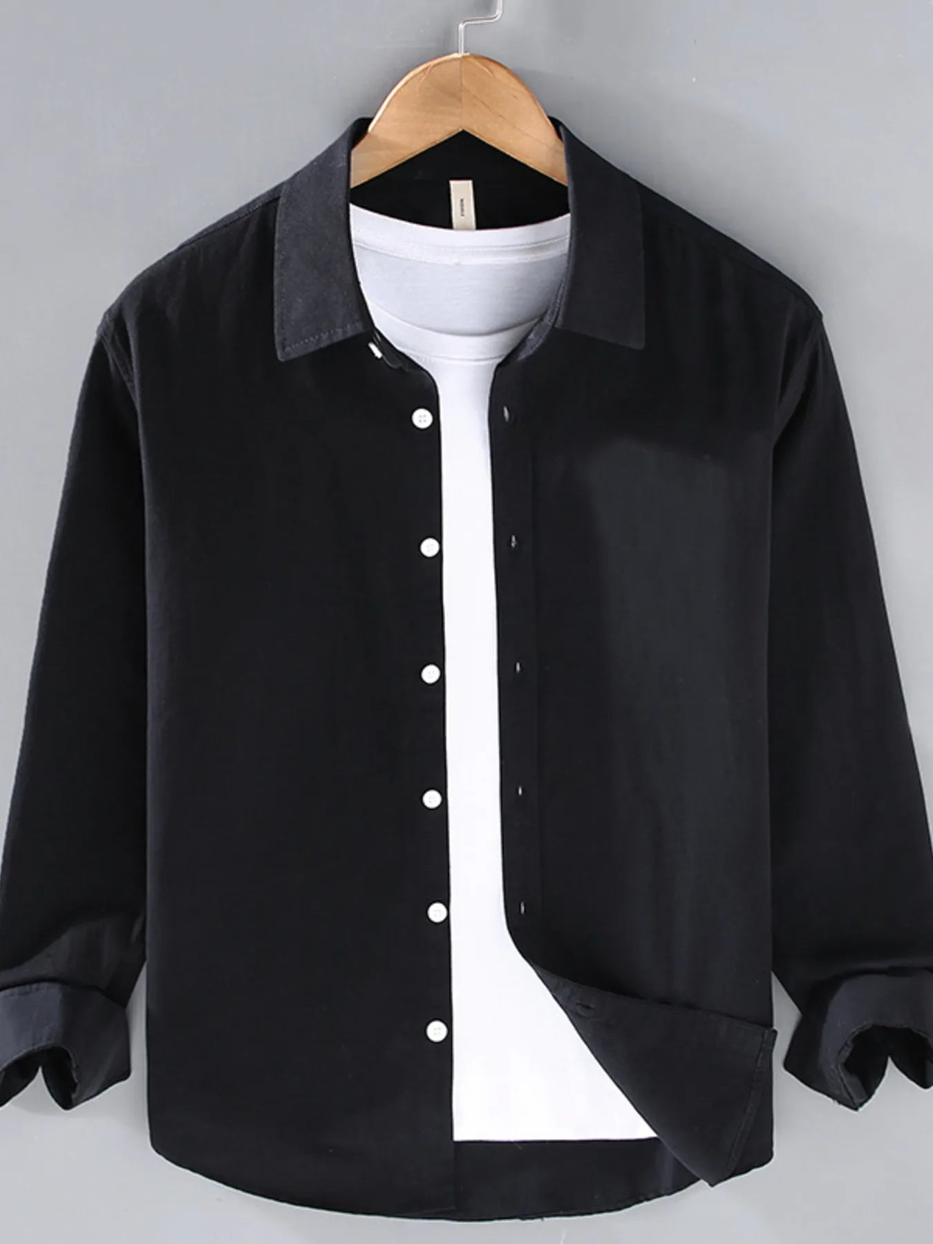 Black button-up long sleeve shirt with pointed collar and front button placket.