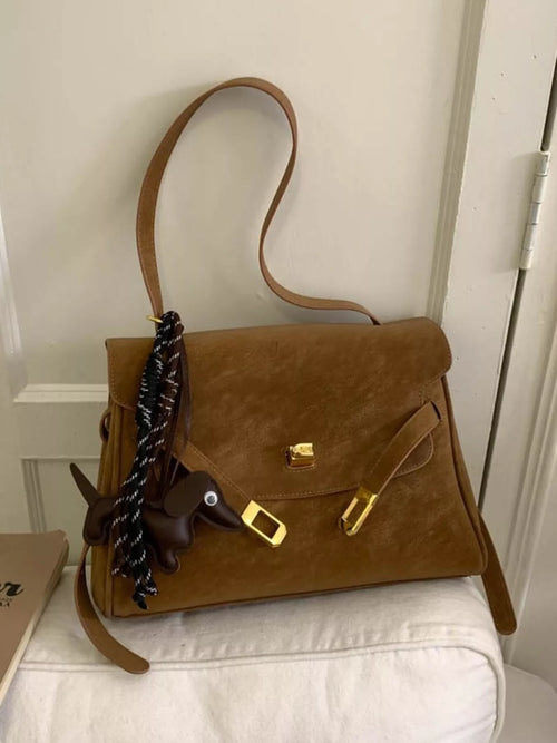 Brown suede buckle shoulder bag with front flap and gold clasp, braided strap