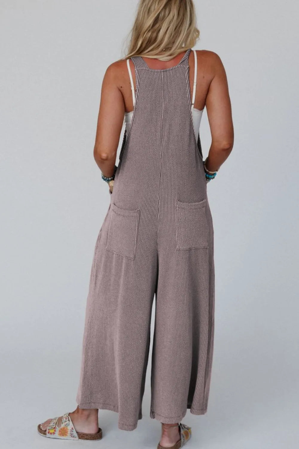 Gray wide-leg overalls with adjustable straps and back yoke seam detail