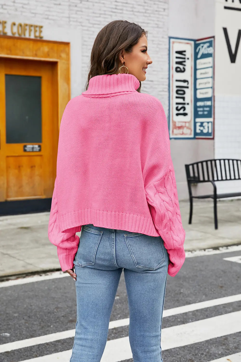 Hot pink cable-knit turtleneck sweater, long sleeves, shown from the back