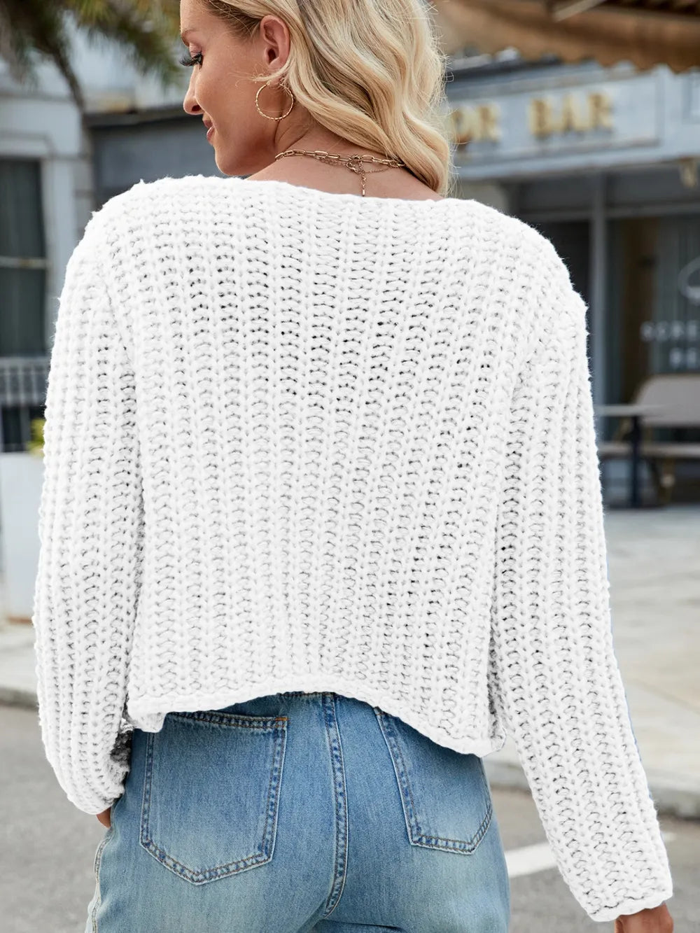 White knit cardigan with round neckline, button front, and patch pockets