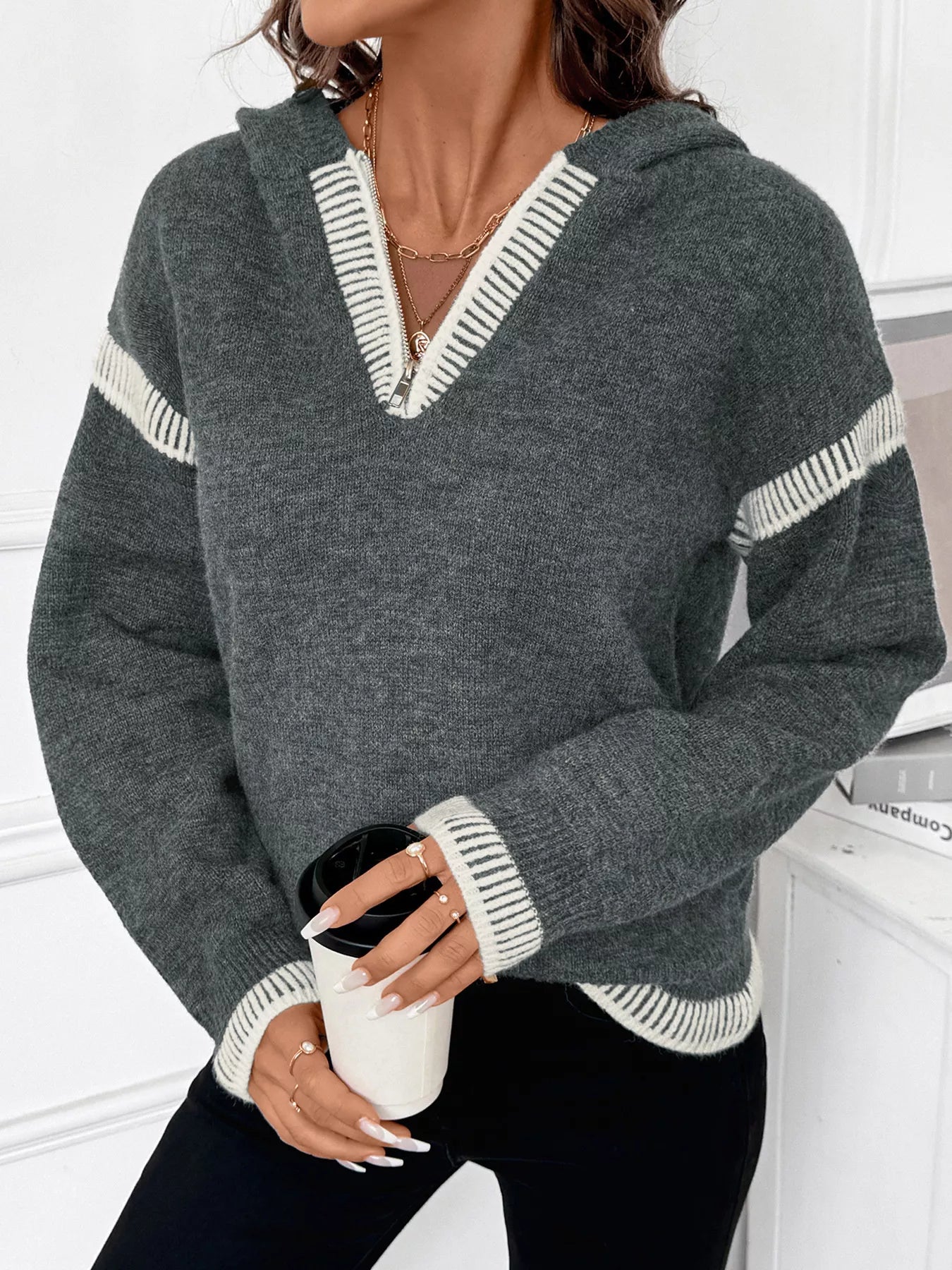 Dark gray hooded quarter-zip sweater with white striped trim along V-neck placket