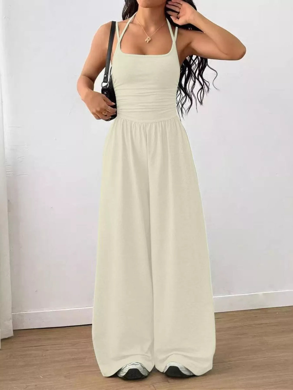 Cream spaghetti strap wide-leg jumpsuit with smocked waist and sleeveless straight neckline