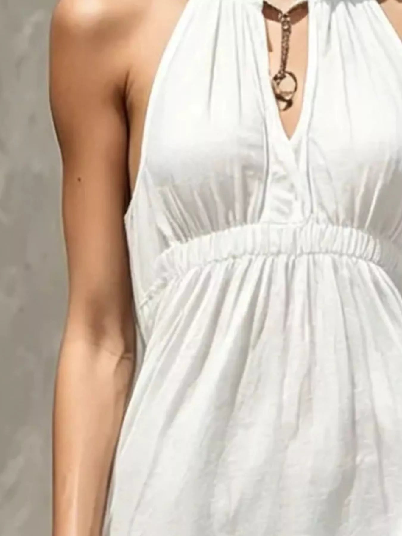 White sleeveless halter maxi dress close-up of smocked bodice and tiered skirt
