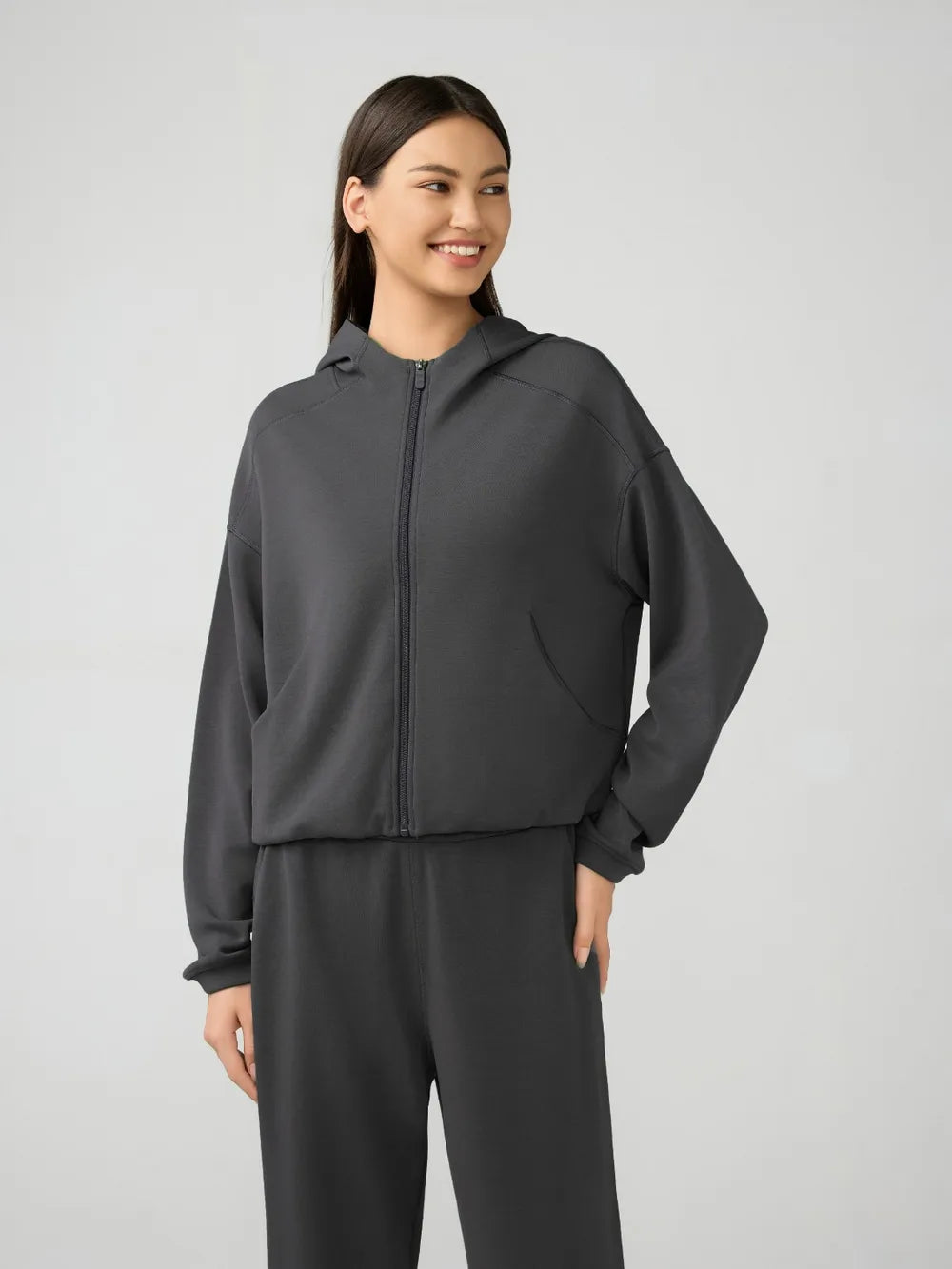Dark gray zip-up hooded active jacket with dropped shoulders and relaxed fit