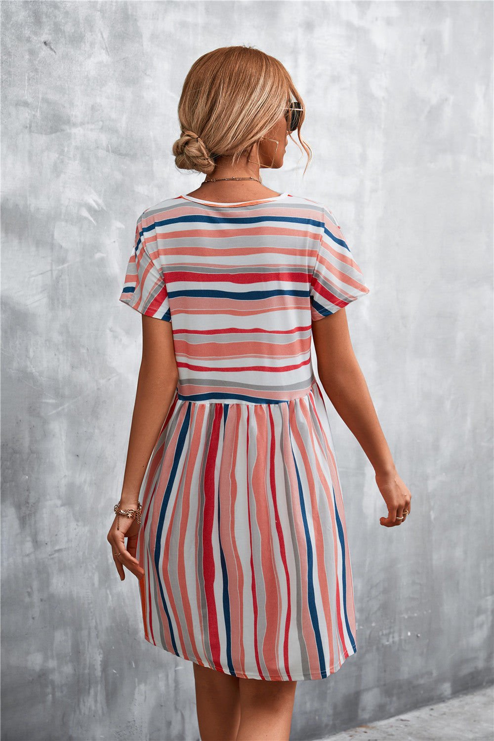 Back view of striped round-neck dress with short sleeves and gathered waist, blue coral stripes