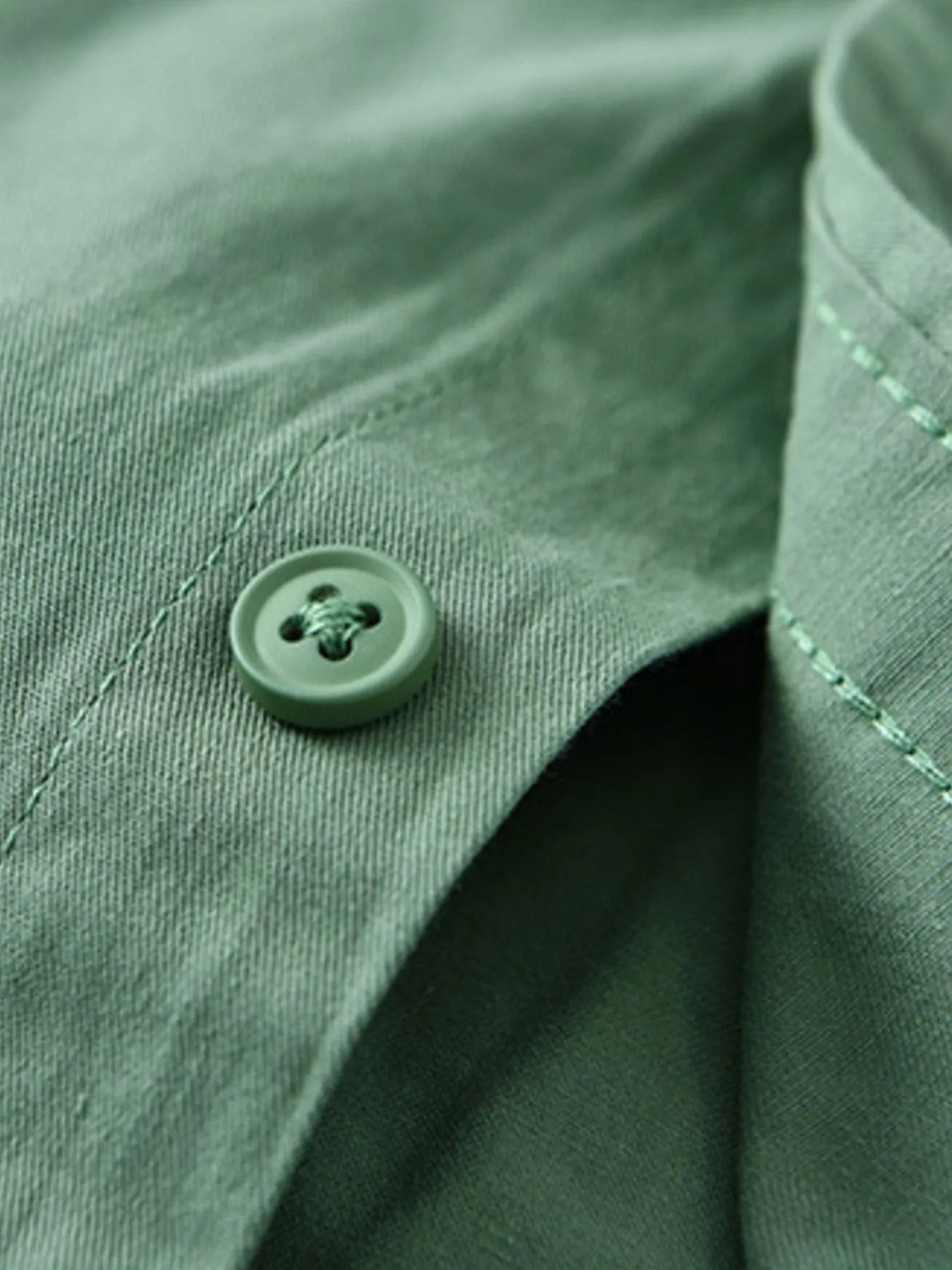 Green short-sleeve shirt cuff with small button detail