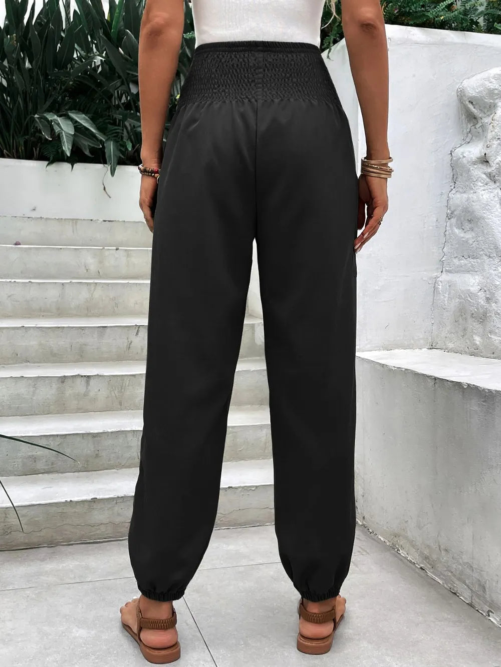Black smocked high-rise joggers with side pockets and ankle cuff elastic