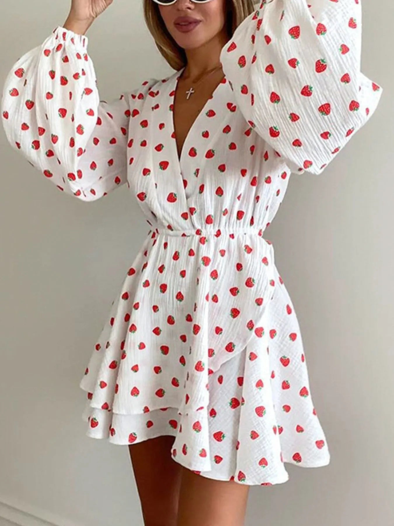 Strawberry print white long-sleeve mini dress with puff sleeves, wrap neckline and ruffled hem