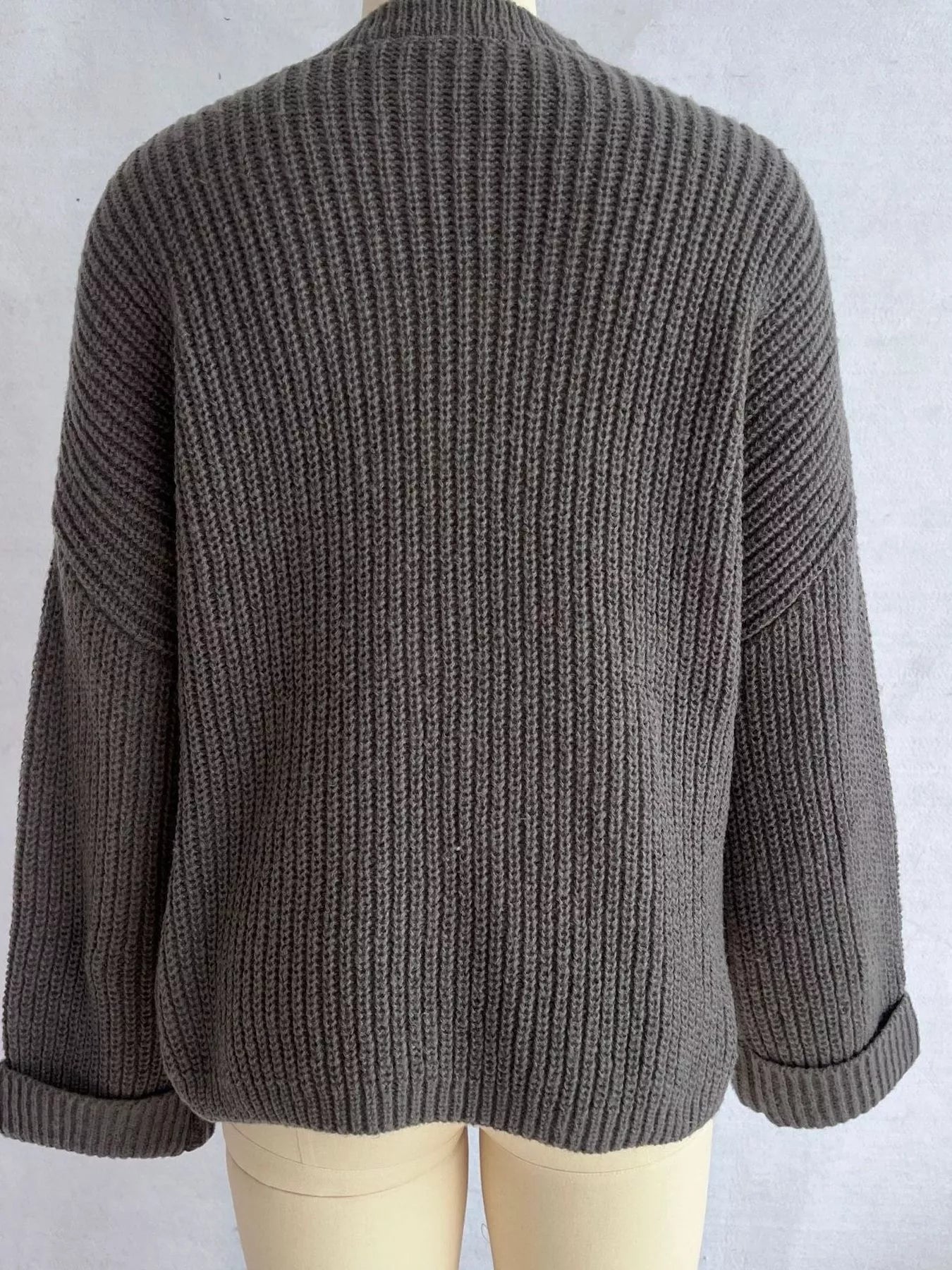 Asymmetrical button-detail sweater in gray, back view with knit texture