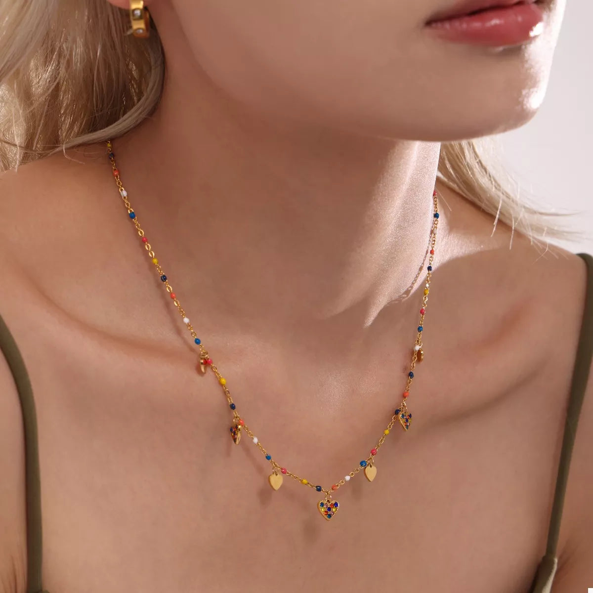 Gold-plated heart charm necklace with blue beads and small gold hearts