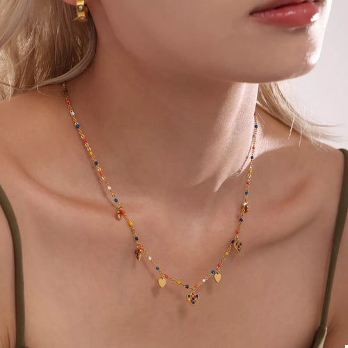 Gold-plated heart charm necklace with blue beads and small gold hearts