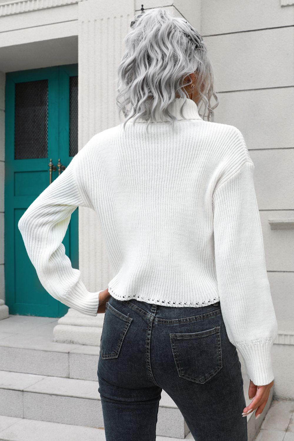 White turtleneck dropped-shoulder sweater, back view, ribbed knit, long sleeves.