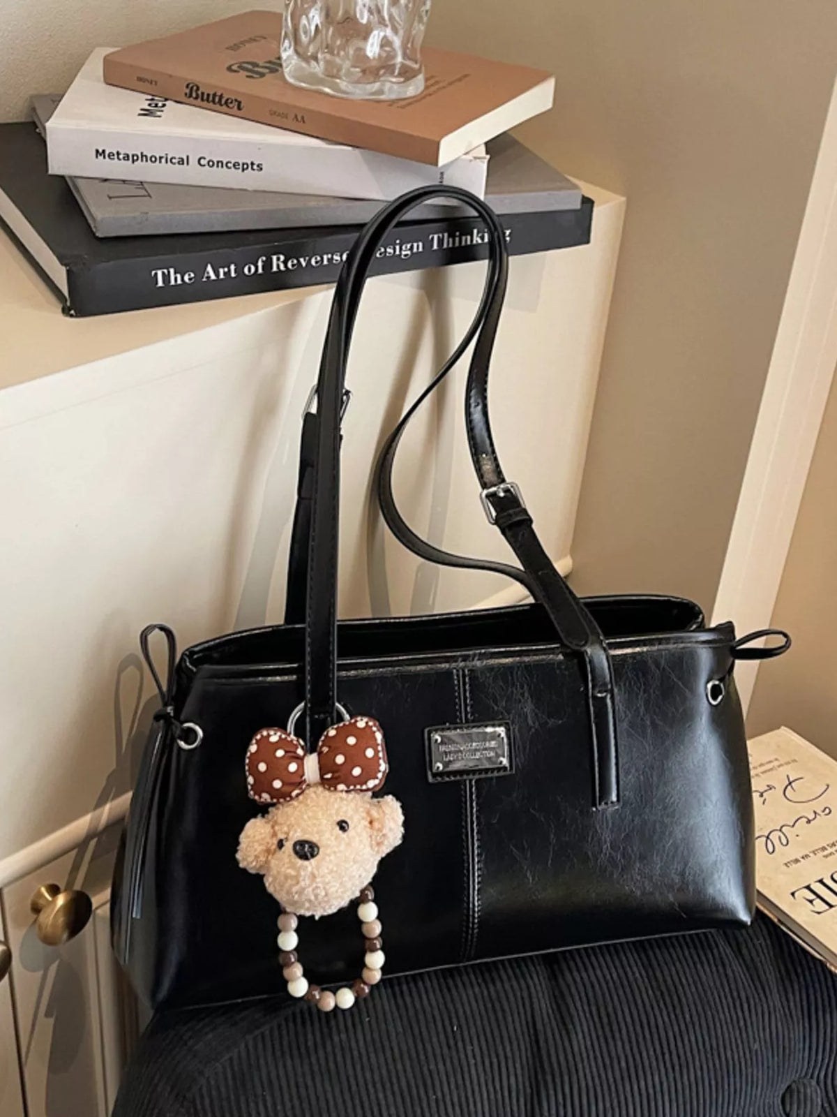 Black vegan leather medium shoulder bag with double handles and teddy keychain on front