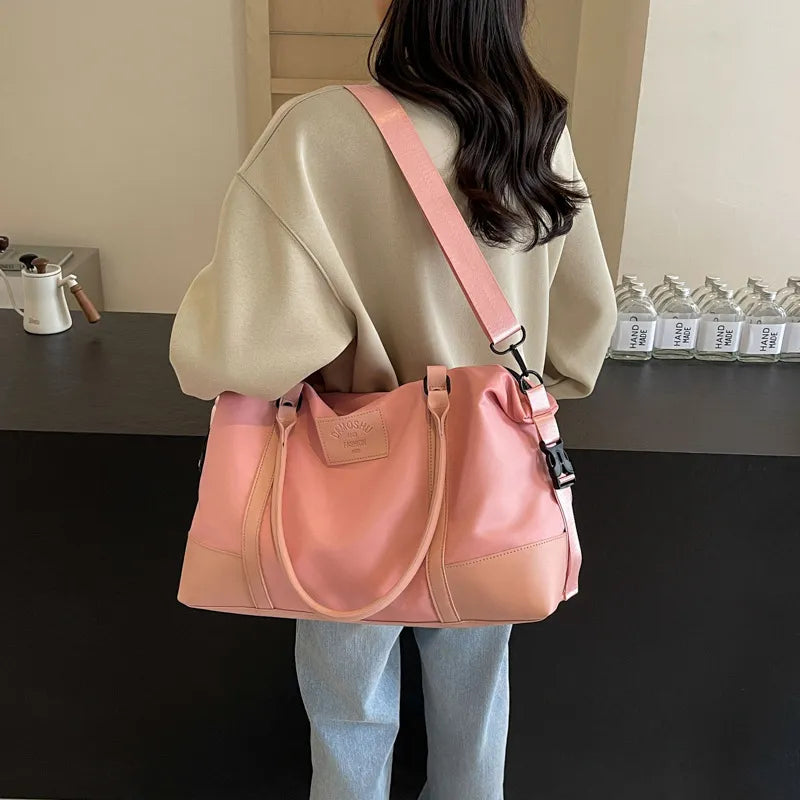 Blush pink polyester travel duffel with detachable crossbody strap and top handles