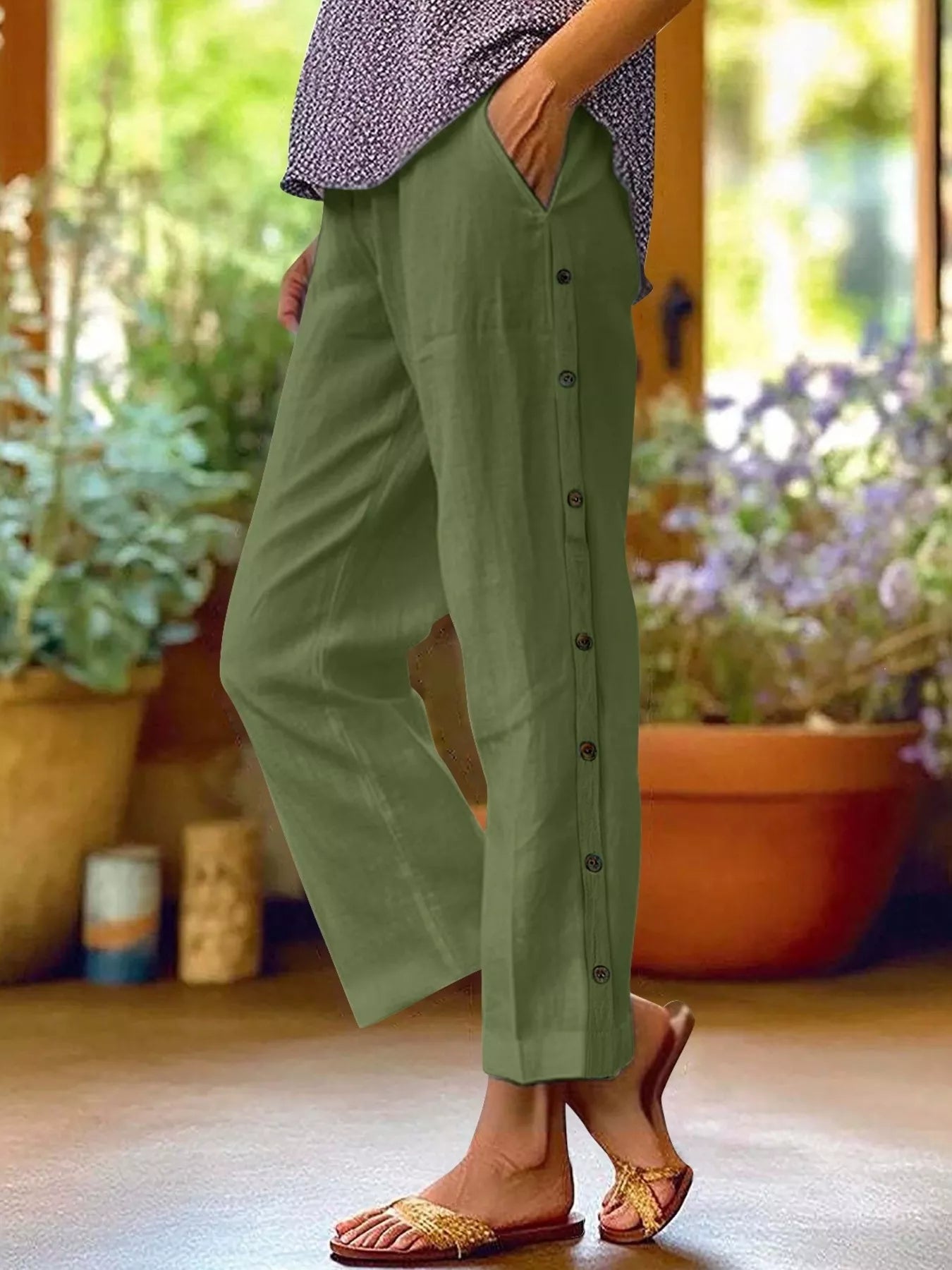 Olive green polyester pants with side buttons and side pockets, relaxed fit