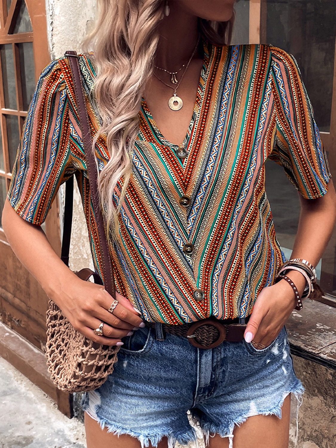 Shiny printed v-neck button-up short sleeve top, front view, multicolor red teal stripe
