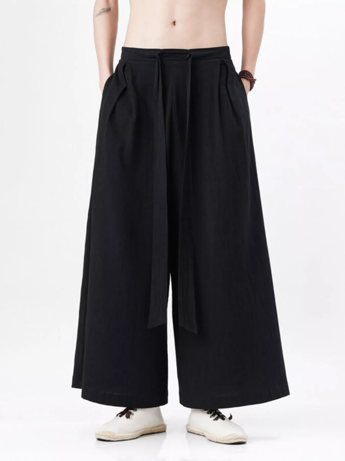 Black wide-leg pants with pleated front and relaxed fit through the legs