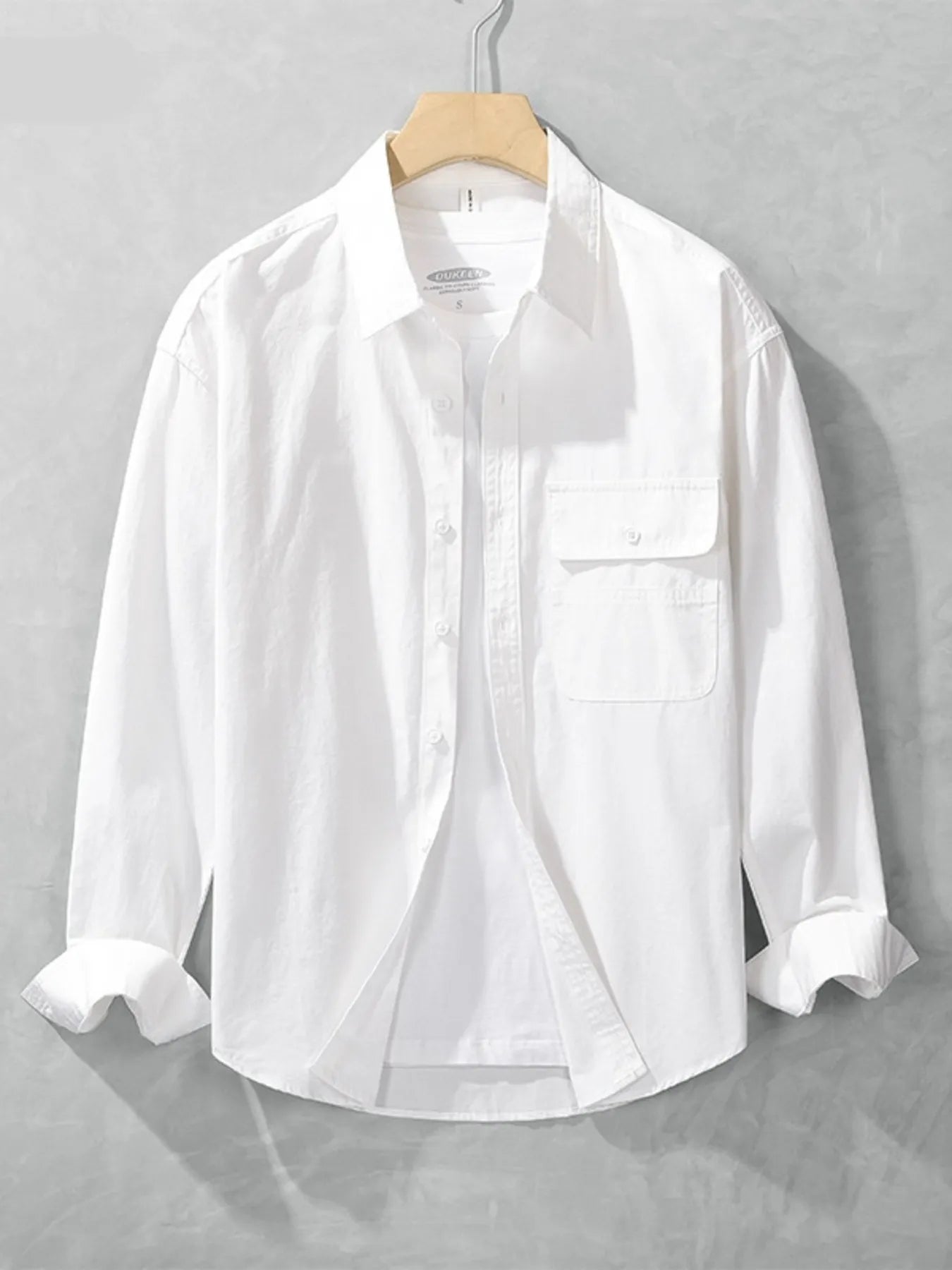 White button-up long sleeve shirt with chest pocket, button front, and spread collar.