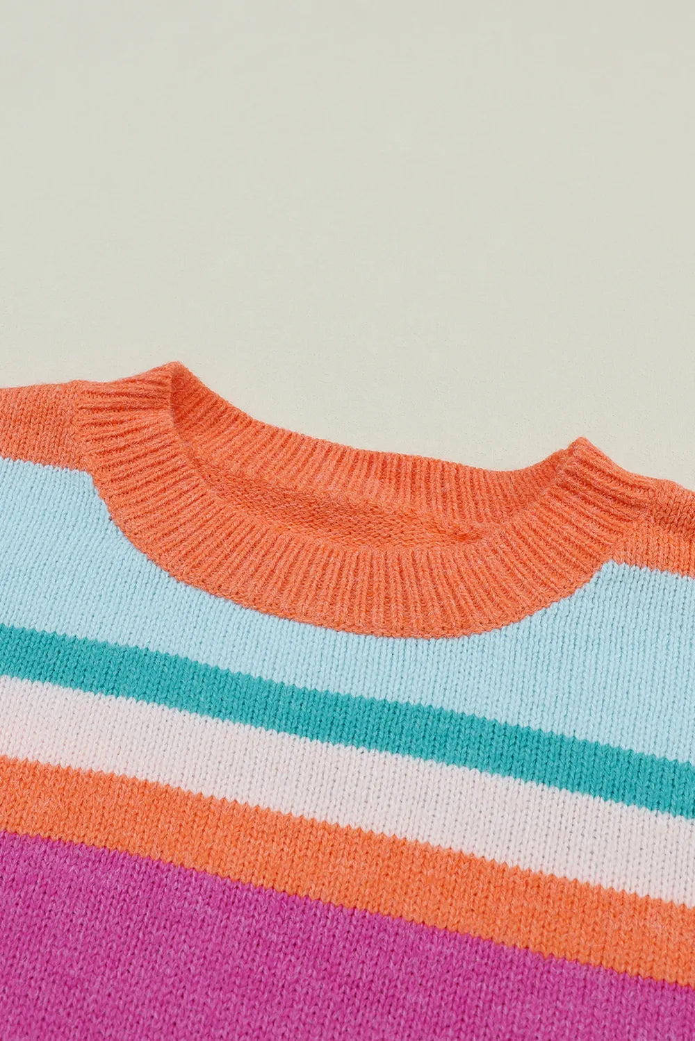 Ribbed round neckline of a multicolor striped sweater with wide horizontal color bands.
