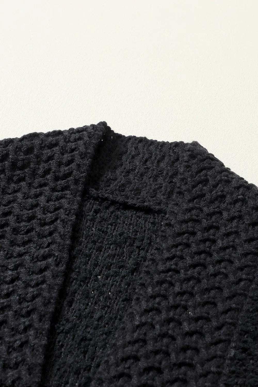 Black textured knit cardigan front placket detail with open V-shape