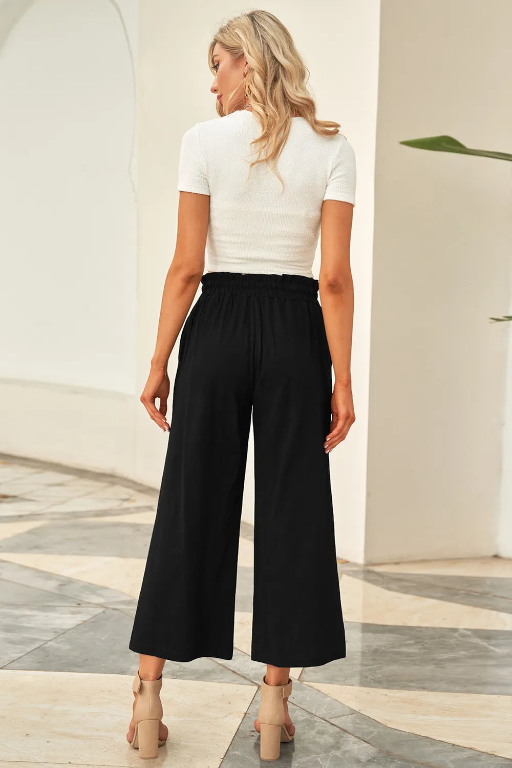 Black wide-leg pants with drawstring paperbag-style waist, shown from the back