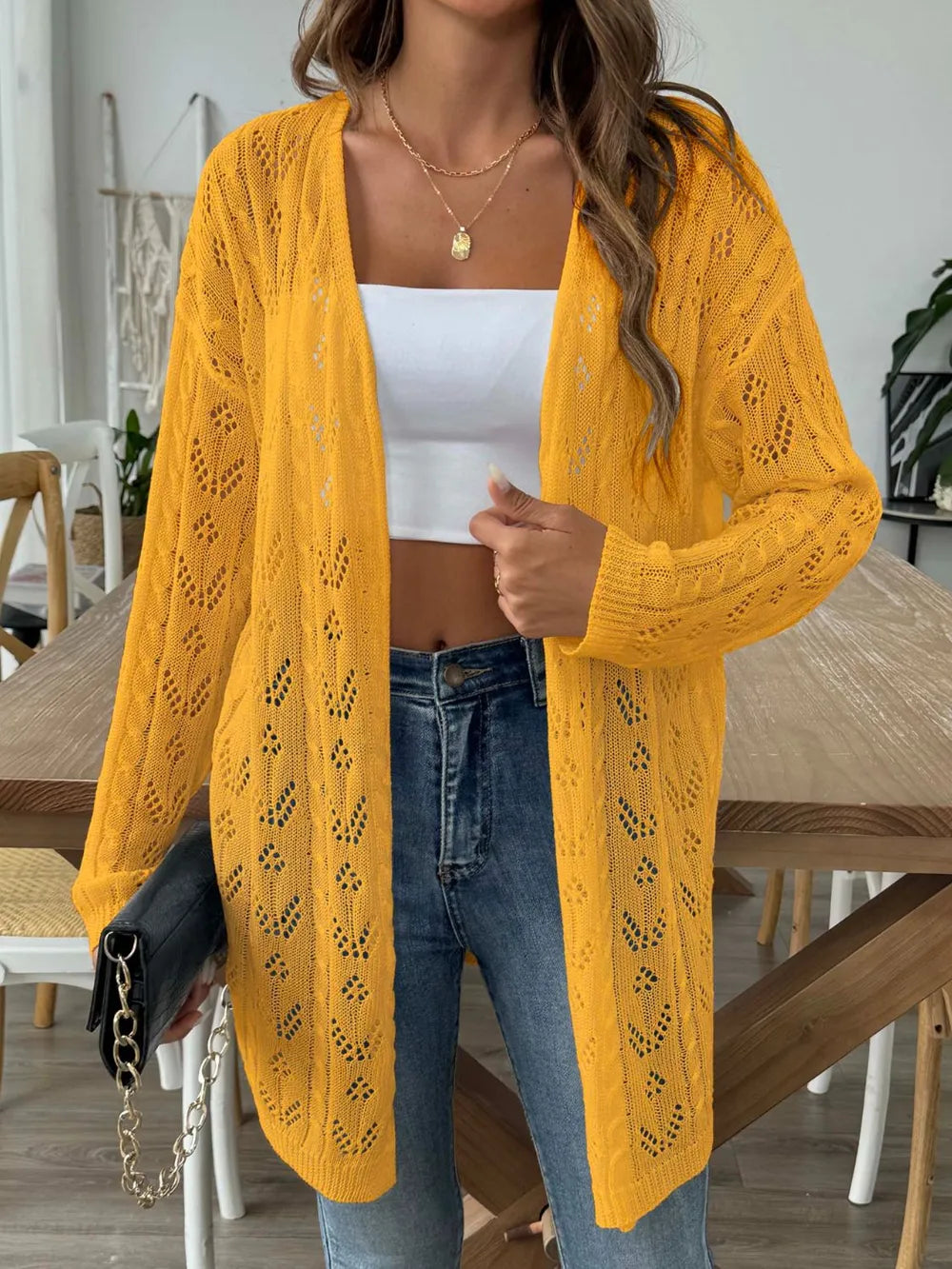 Gold openwork long-sleeve cardigan, open front, textured knit and curved pockets.