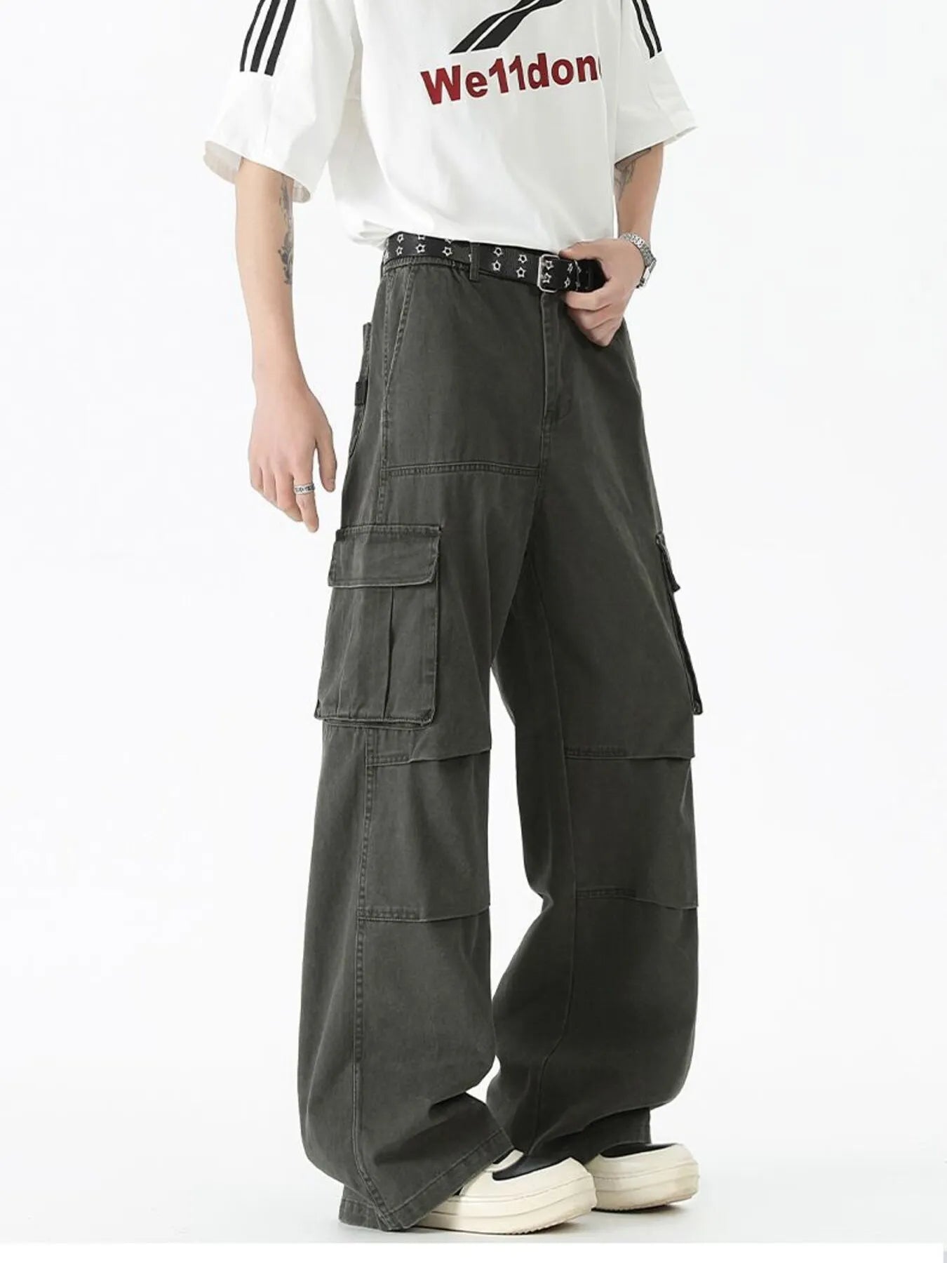 Dark green wide-leg cargo pants with stacked cargo pockets and studded belt