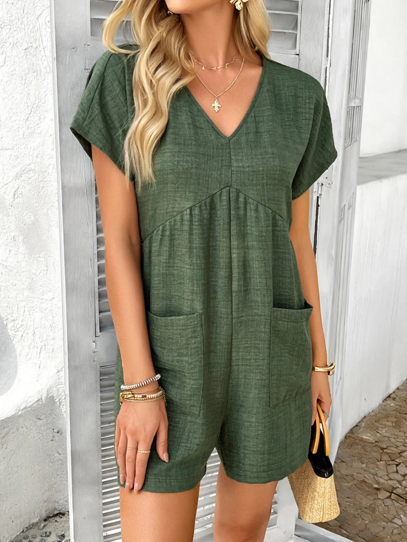 V-neck short sleeve romper in dark green with front pockets and relaxed fit