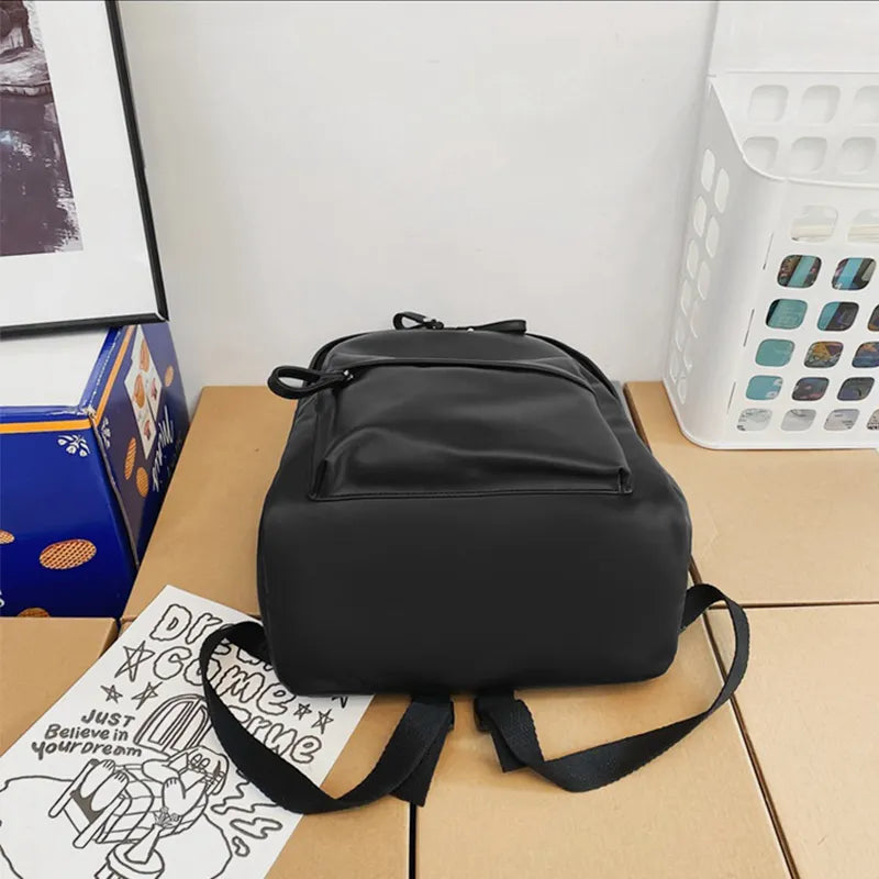 Black vegan leather zip backpack with front zip panel and adjustable shoulder straps