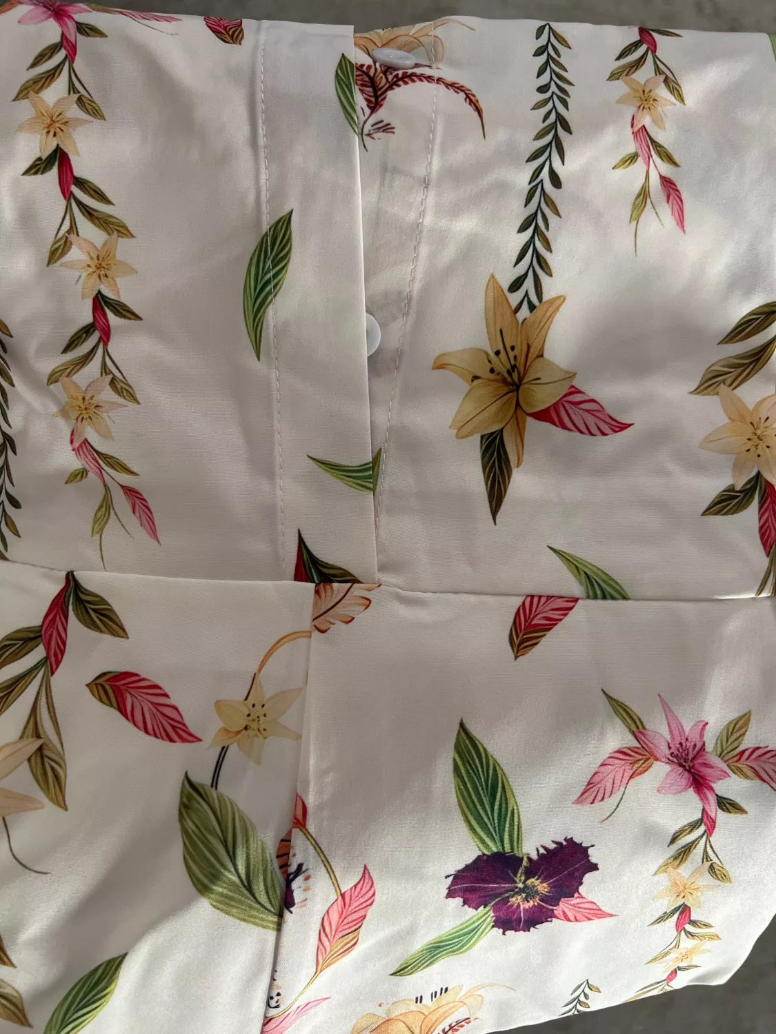White floral romper with button front and tie waist, printed close-up