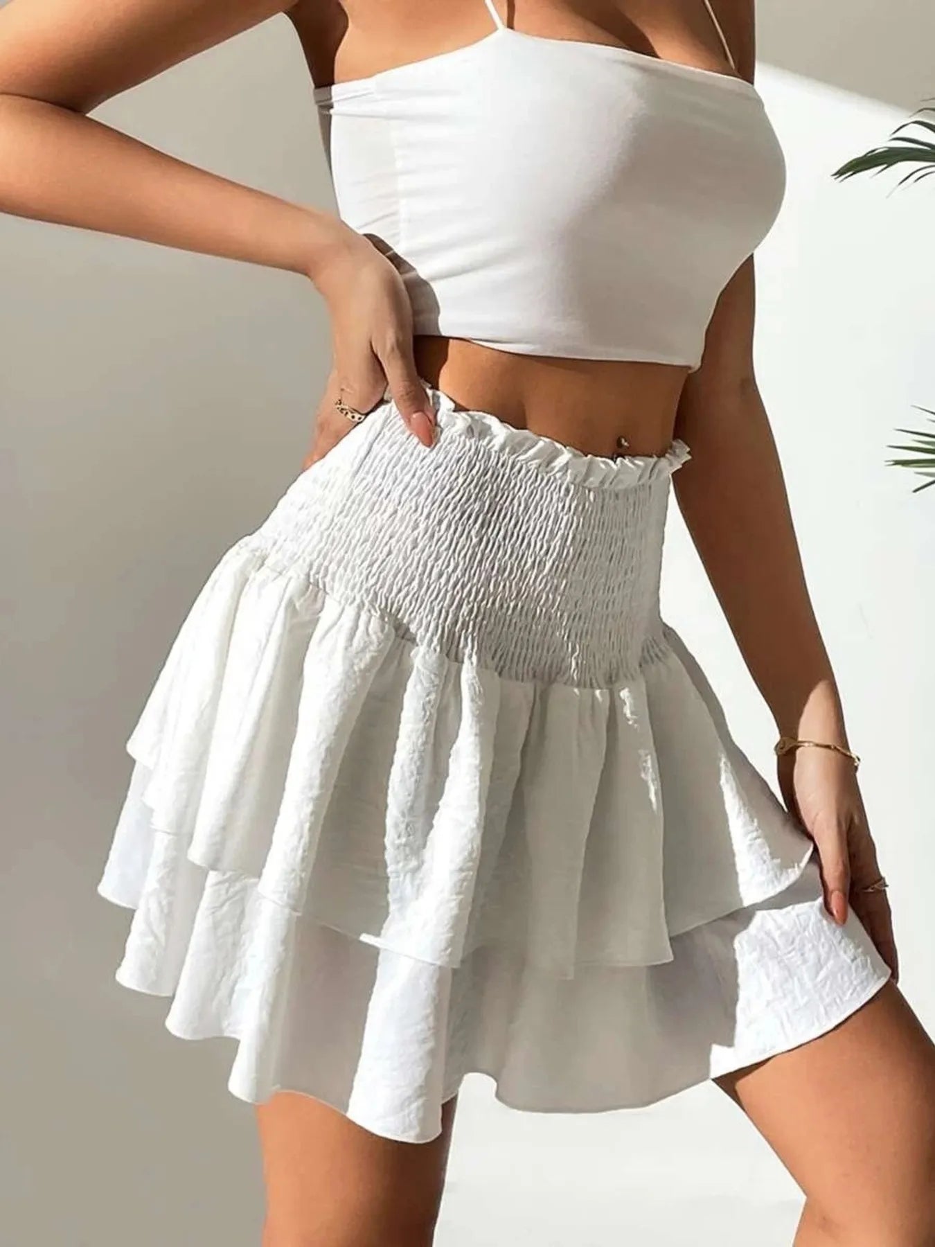 White smocked mini skirt with layered flounce tiers and ruched waistband