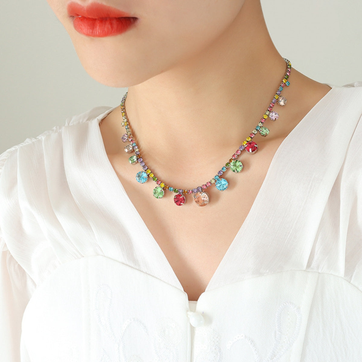 Crystal charm necklace with multicolor stones on gold-tone chain at neckline