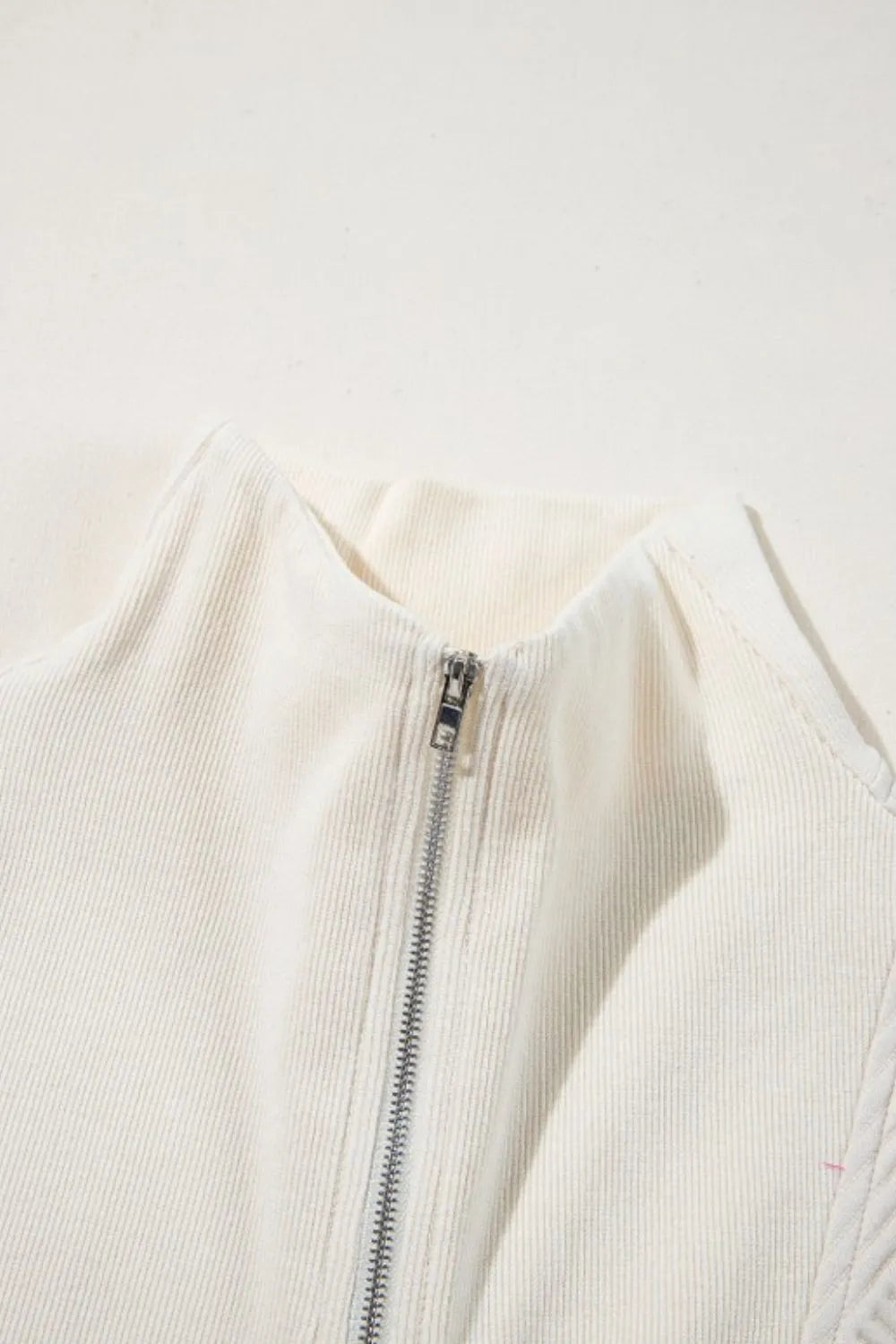 Cream textured romper with center front zipper and stand collar