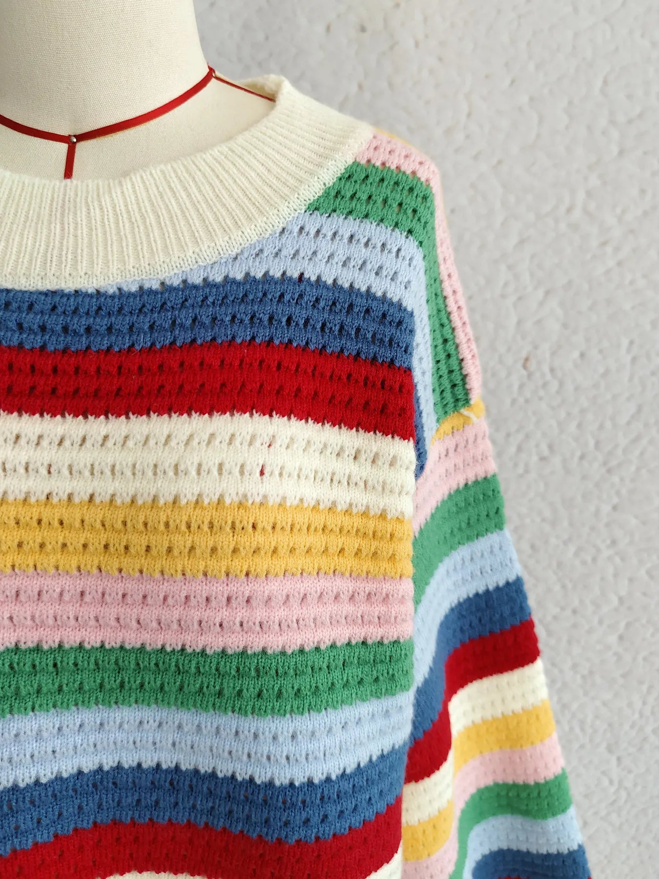 Rainbow striped long-sleeve sweater with ribbed crewneck and colorful knit bands