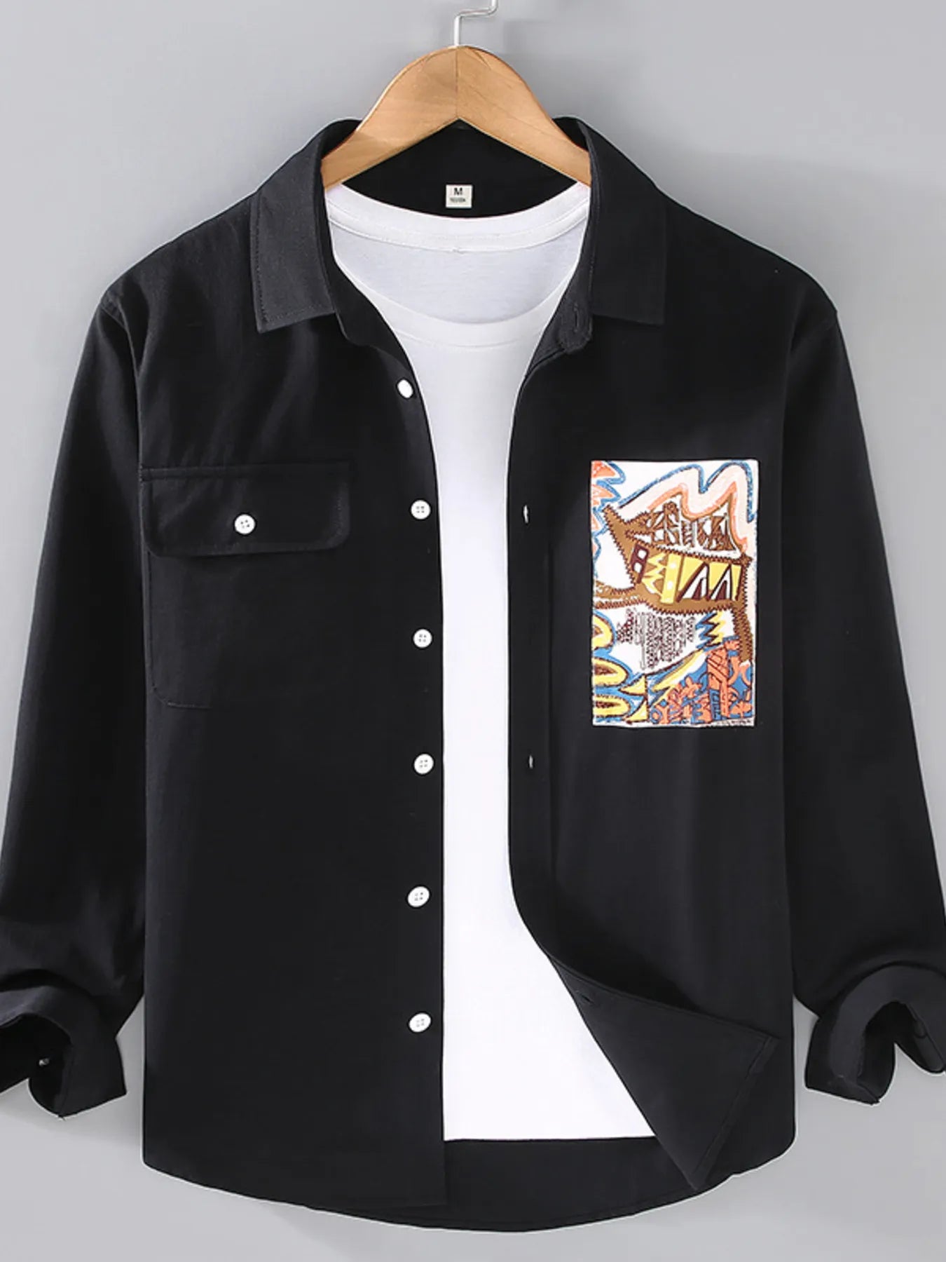 Black button-up long sleeve shirt with chest pockets and front buttons, graphic patch