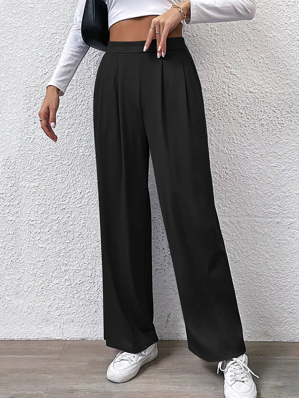 High-waist straight black pants with front pleats and belt loops