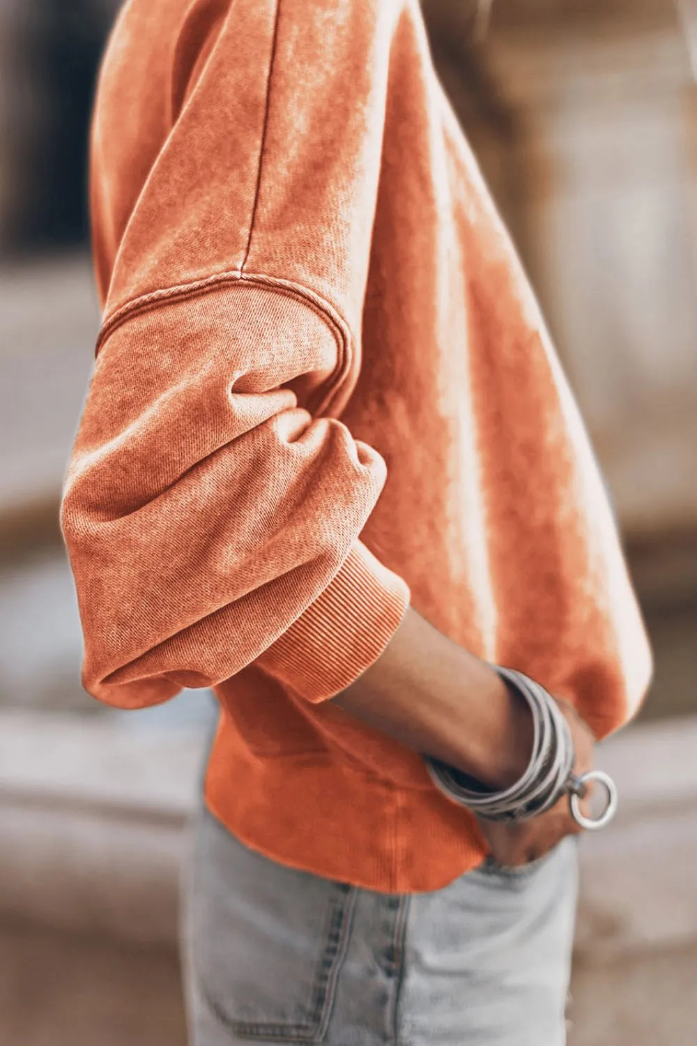 Orange sweatshirt sleeve cuff with ribbed edge detail