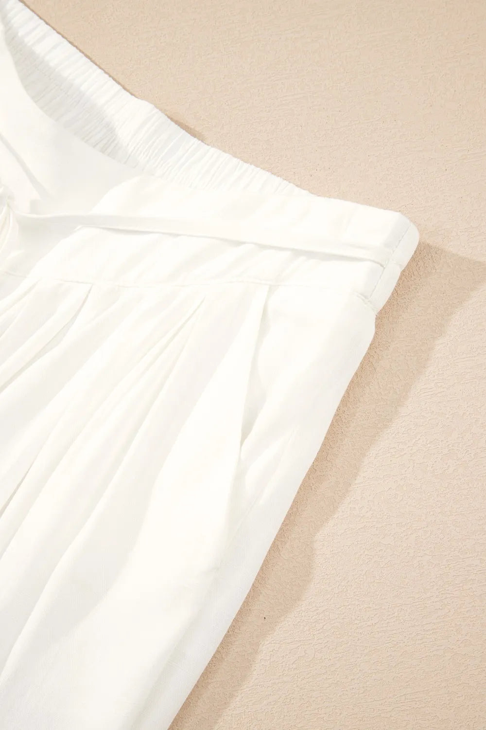 White elastic waist with drawstring on wide-leg pants, close-up