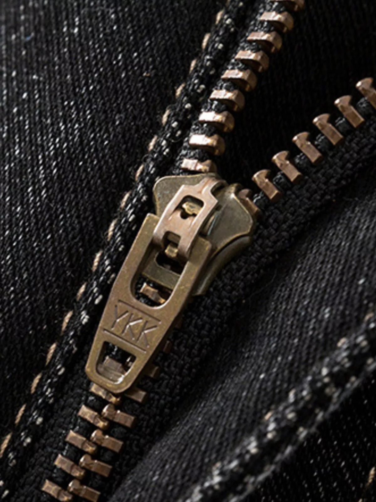 Dark denim jeans zipper with metal pull and stitched teeth detail
