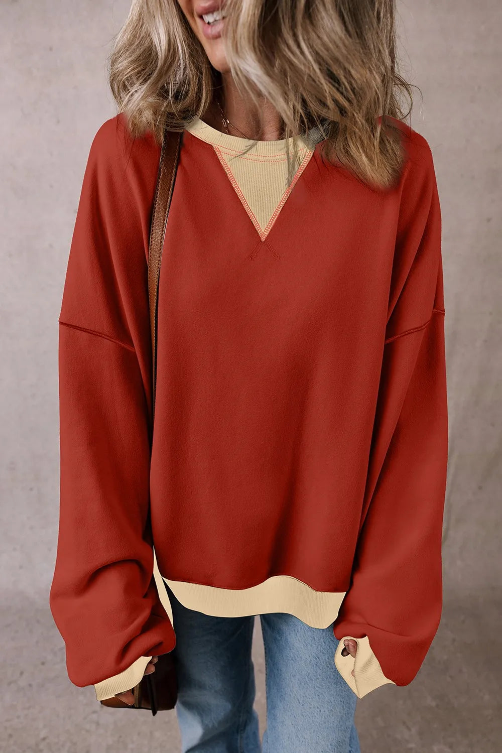 Rust red long-sleeve sweatshirt with light contrast hem and V yoke neckline