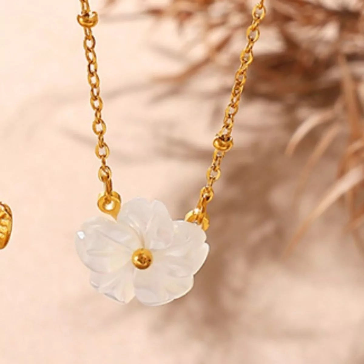 Gold-tone chain necklace with white flower pendant and small round center