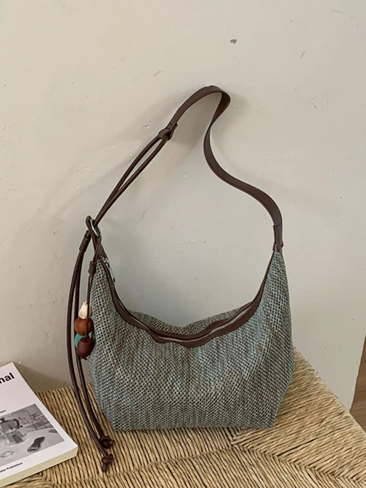 Medium woven shoulder bag with adjustable strap, gray-blue color and brown trim
