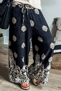 Black wide-leg pants with white ornate print and decorative border hem