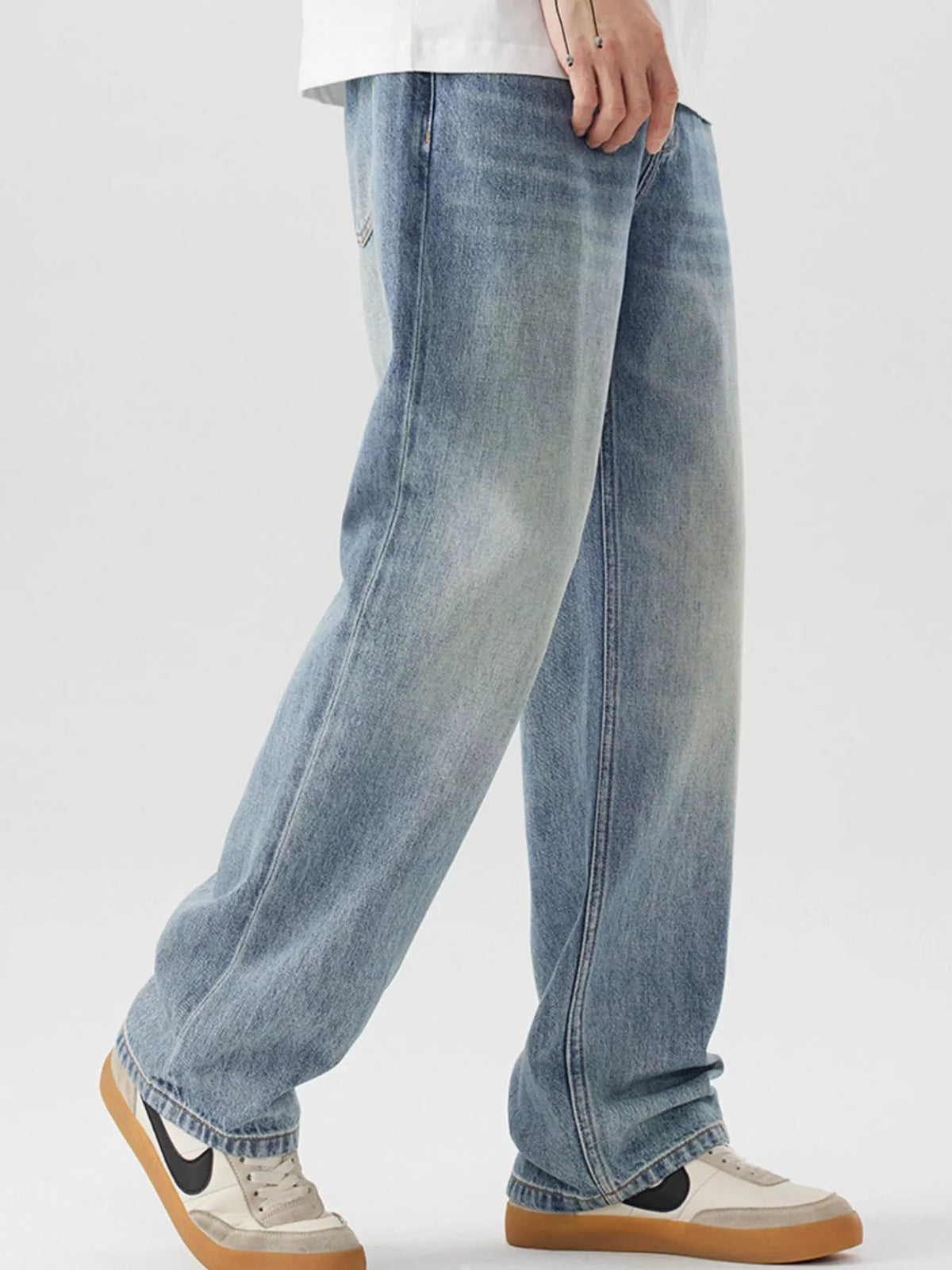 Blue loose-fit cotton jeans, angled side view with thigh seam details