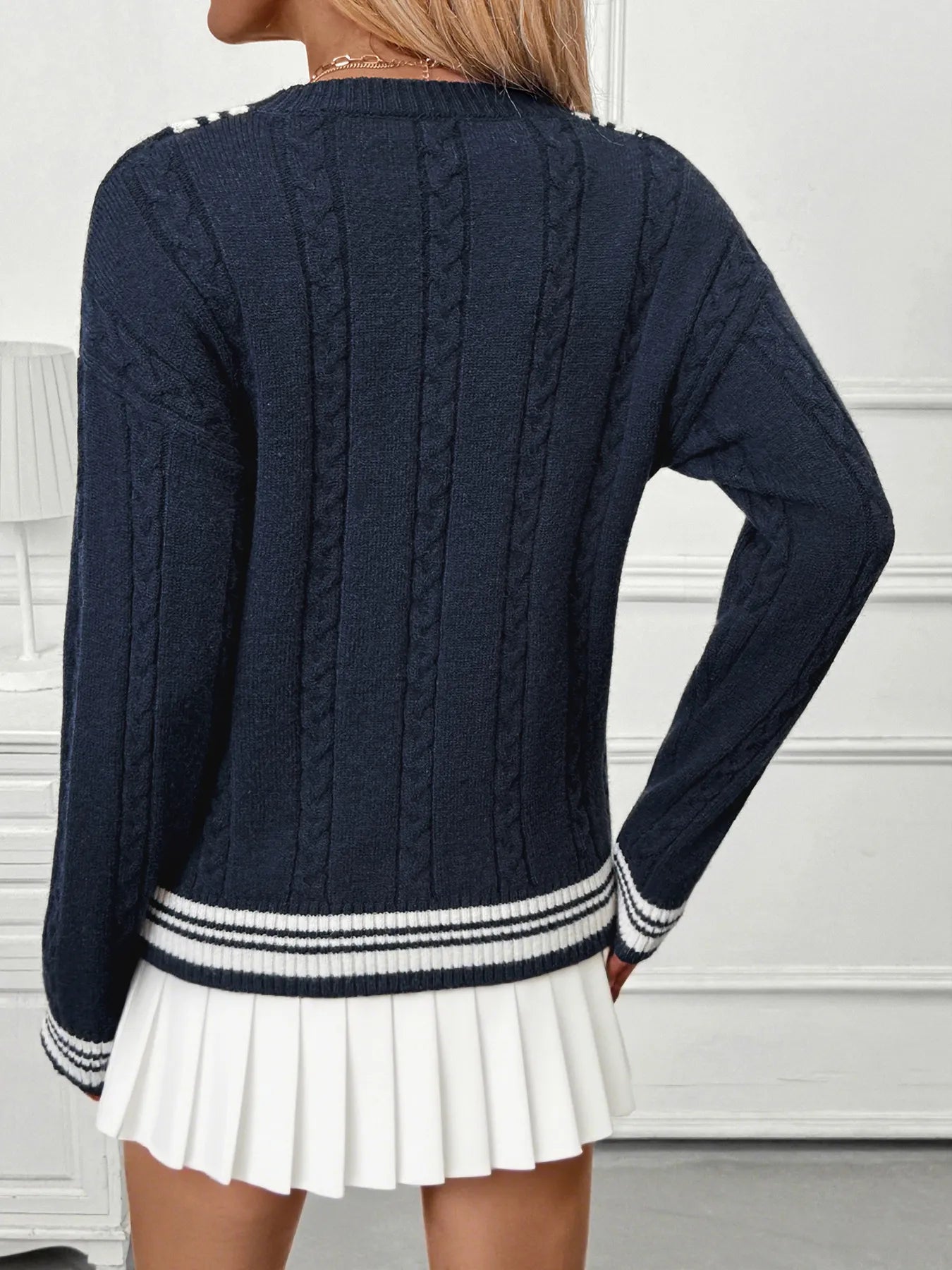 Dark blue V-neck sweater back view with contrast striped hem and cuffs