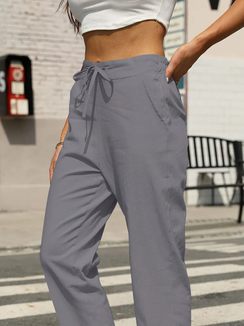 Gray elastic-waist tapered pants with front drawstring and slanted side pockets