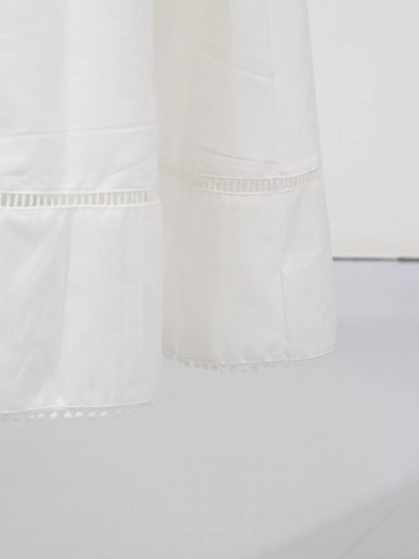 Cedar & Moore Sleeveless eyelet-embroidered button-down midi dress; white fabric with delicate trim.