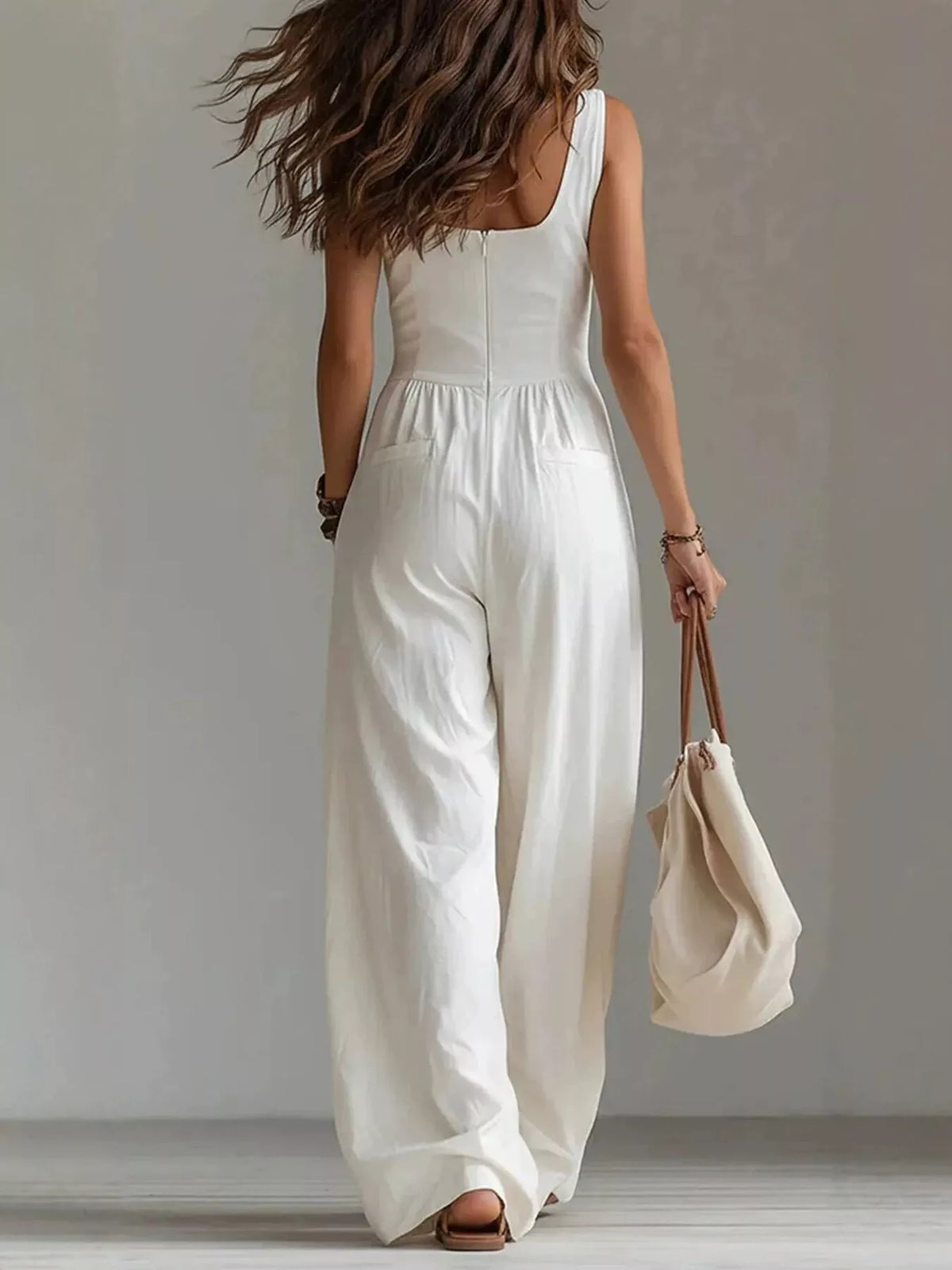 White sleeveless jumpsuit with button front, gathered waist, roomy wide-leg pants