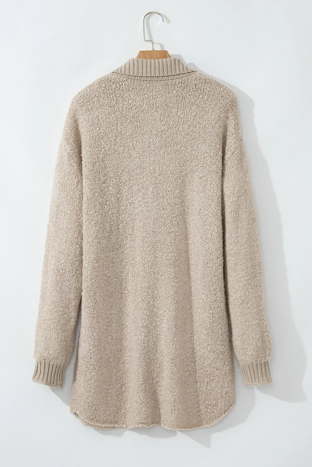 Dust Storm textured knit cardigan back view with ribbed cuffs and hem, on hanger